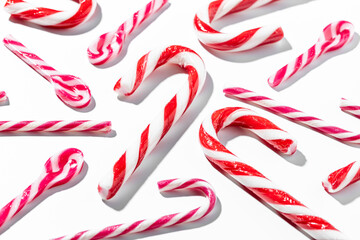 Top view of assorted red and white candy canes on white background
