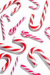 Top view of assorted red and white candy canes on white background