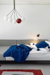 This modern bedroom features stylish decor elements and unique lighting for an inviting atmosphere