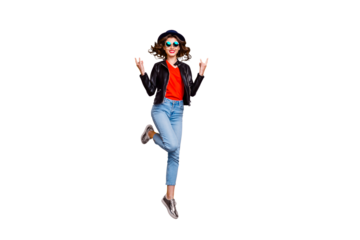 Full length photo of cheerful girl with curly hairstyle jump show horned sign rock on pank concert wear denim jeans good look isolated over yellow color background