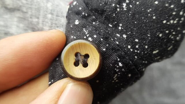 Macro video of plastic buttons attached to a black shirt