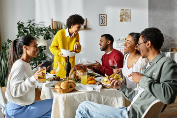 Close friends gather around a table to share a festive Thanksgiving meal and laughter.