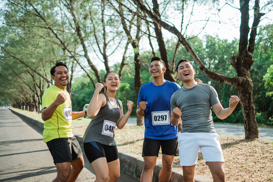 asian sporty people celebrating marathon victory in a park
