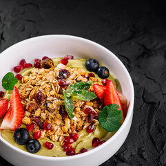 Fresh fruit and granola bowl on dark background