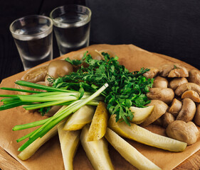 Wooden board with vodka and appetizers for drinking