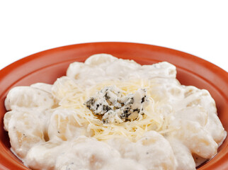 Gnocchi with four cheese sauce garnished with blue cheese on a plate