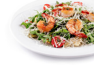 Mediterranean diet dish with shrimps, pasta and parmesan cheese being served on white plate