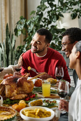 A group of friends joyfully shares a Thanksgiving meal filled with laughter, food, and warmth.