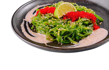 Fresh seaweed salad with tobiko garnish and lime