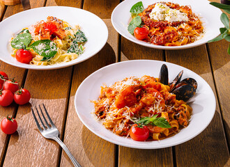 Assorted italian pasta dishes on wooden table