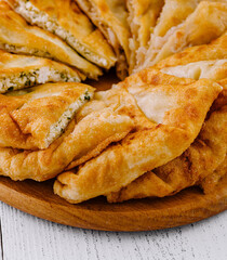 Delicious golden pies with filling lying on wooden board © AntAlexStudio
