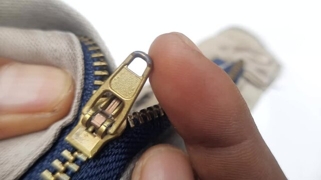 Golden yellow zipper pants being checked by someone on a white background