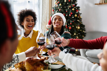 Friends celebrate Christmas together at home, sharing laughter, toasts, and delicious food.