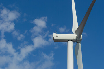 Close-up of wind turbine against blue sky. Concept of green, clean, renewable energy.