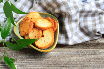 Toasted crisps seasoned with herbs on a small plate.