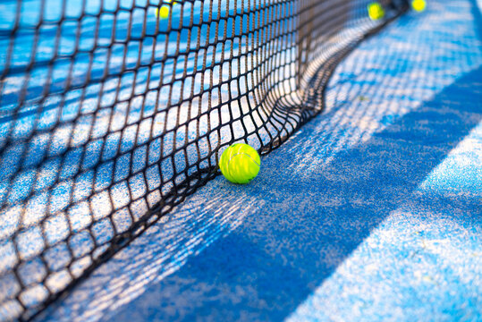 tennis ball on blue court lie near net. space for text. sport tennis or padel.  activity interesting game. trading.