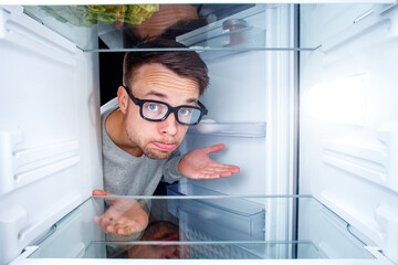 Man Disappointed by Empty Fridge