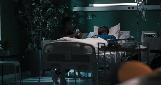 Devoted partner sits beside her boyfriend in the hospital, offering solace and support during his recovery.