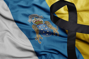 waving national flag of canary islands with black mourning ribbon .tragedy concept