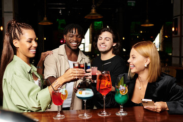 Colleagues toast with colorful cocktails, enjoying a fun and upbeat corporate party atmosphere.