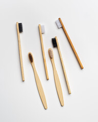 Top view of eco-friendly bamboo toothbrushes arranged on grey white background, emphasizing sustainability and minimalism, Natural organic bathroom beauty product concept, dental .hygiene, flat lay