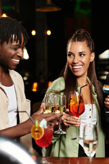 At a vibrant corporate party, young professionals raise their glasses in joyful celebration.