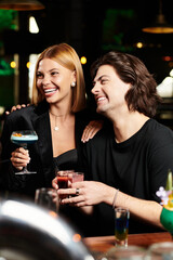 Colleagues enjoy drinks and laughter while celebrating at a festive corporate party.