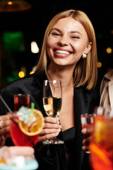 Woman enjoy a lively corporate gathering, raising glass.