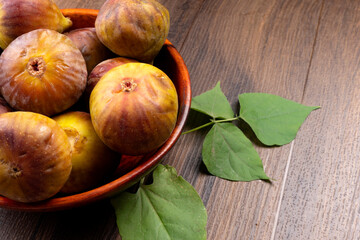 Freshly ripe figs. Healthy Mediterranean fig fruit. Fresh figs on a dark background. Beautiful blue violet figs with leaves, copy space, closeup.