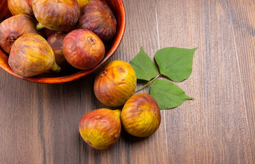 Freshly ripe figs. Healthy Mediterranean fig fruit. Fresh figs on a dark background. Beautiful blue violet figs with leaves, copy space, closeup.