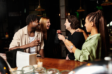 Diverse professionals enjoying drinks and laughter at a fun corporate party with friends.