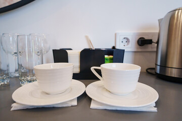 two empty white tea or coffee cups on a table in the hotel room.