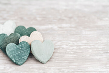 Fototapeta premium Pastel Colored Wooden Hearts Lined Up on Rustic Background for Creative Love Concepts