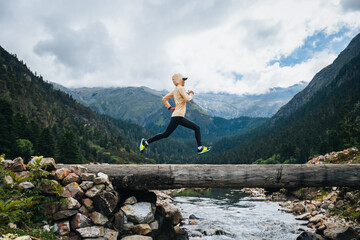 Woman trail runner cross country running in high altitude mountains