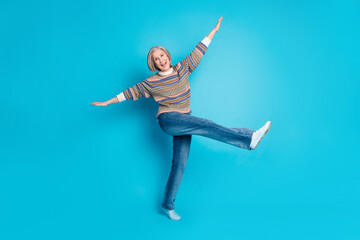 Full length photo of optimistic person wear ornament pullover standing on one leg hands like wings isolated on blue color background