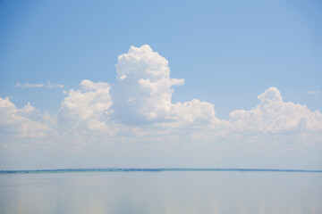 A beautiful blue sky with cumulus clouds over the sea surface. seascape.