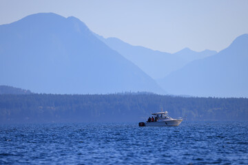 a fishing boat off the coast of Vancouver Island with many layers of mountains at the horizon