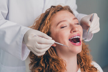 Photo of professional dentist examining teeth of patient with in clinic