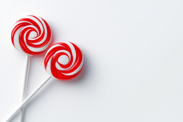 Photo of red and white lollipops on white background with space for text.
