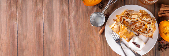 Sweet homemade pumpkin strudel. Tasty autumn pumpkin squash strudel cake with walnut and cinnamon, topped with vanilla ice cream scoop
