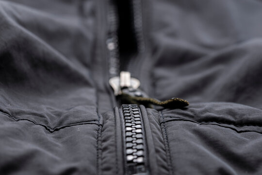 Detalle de una cremallera de una chaqueta negra  cerrada