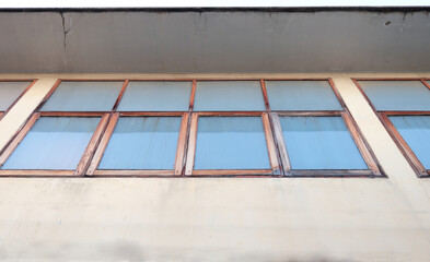 Exterior wood window rectangle shape frame row with tint glass under roof of retro house in Thailand.