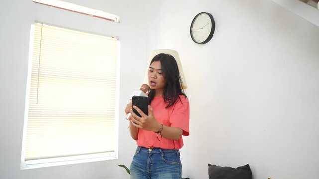 Pretty Asian Girl Singing With A Wireless Microphone And Recoding Video On A Phone