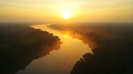 A hazy sunset casting a soft, golden light over a calm river, with humid weather creating a misty atmosphere as the sun dips below the horizon. 