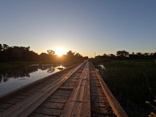 Obraz premium ponte de madeira na rodovia transpantaneira fotografada no por do sol 