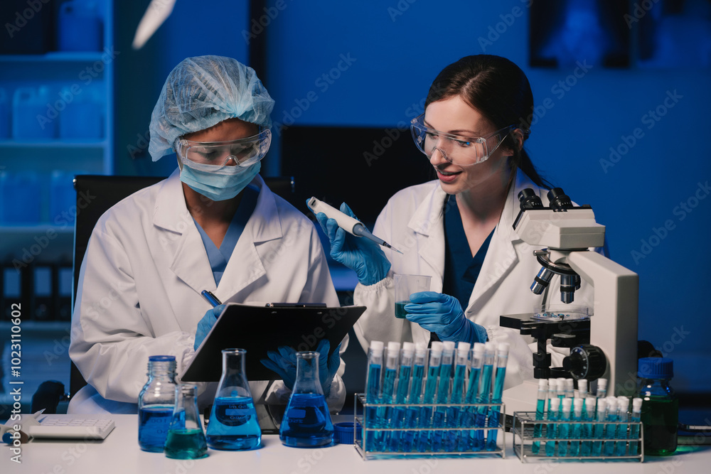 Wall mural team of biochemical research scientists working with a microscope for vaccine development
