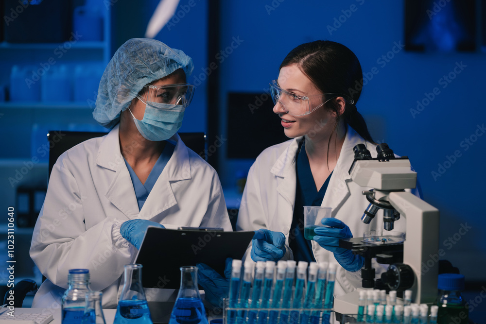 Wall mural team of biochemical research scientists working with a microscope for vaccine development