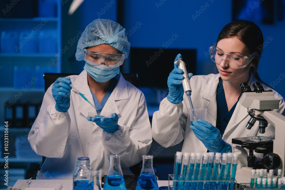 Wall mural team of biochemical research scientists working with a microscope for vaccine development