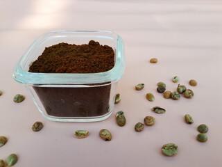 Coffee powder in a glass bowl and sprinkled with coffee beans