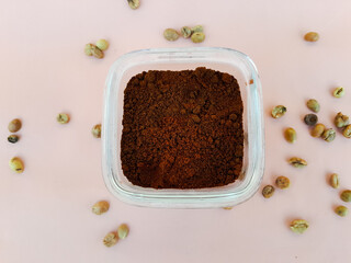 Coffee powder in a glass bowl and sprinkled with coffee beans